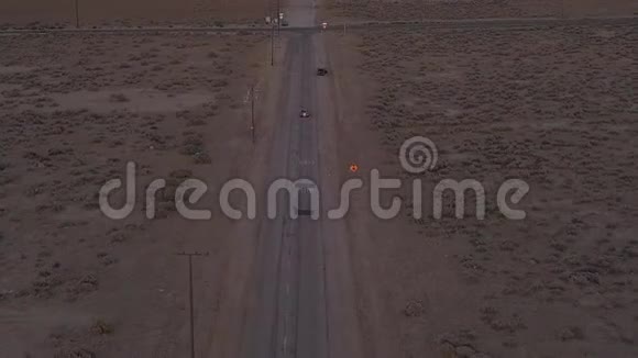 艾琳飞越洛利废弃的沙漠公路红色汽车在远处行驶视频的预览图