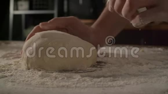 厨师在厨房的桌子上用面粉揉搓面团慢动作烹饪视频的预览图
