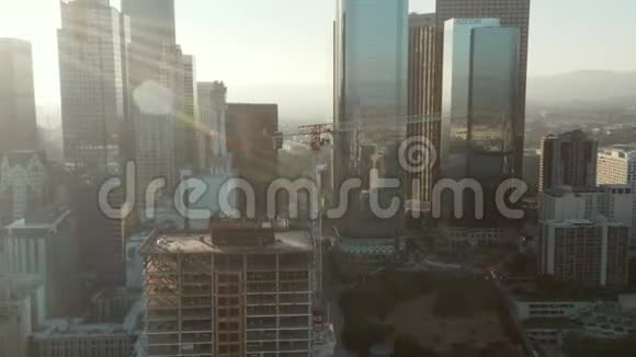 飞机飞往洛杉矶市中心的建筑工地摩天大楼在美丽的蓝天上飞行视频的预览图