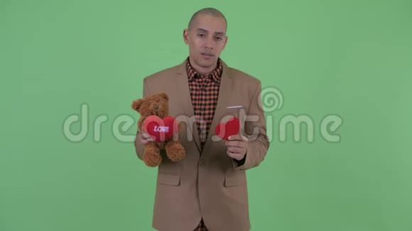 可怜的秃头多民族商人抱着玩具熊情人节视频的预览图