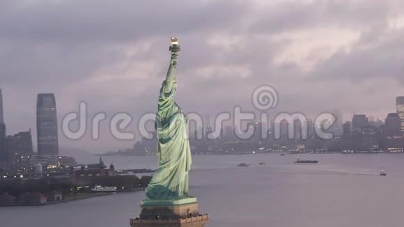 光环自由女神像在清晨的灯光下闪耀背景是多雾的纽约市天际线视频的预览图