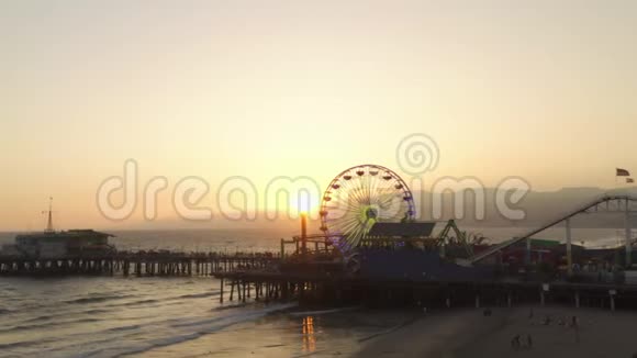 阿里亚在美丽的日落时分靠近圣莫尼卡码头弗赖斯轮与游客行人一起观看洛杉矶美丽的日落视频的预览图