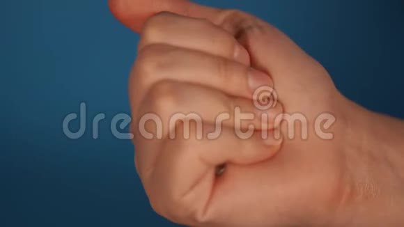 女人手张开拳头用钥匙特写女人的一把钥匙蓝色背景上的手掌视频的预览图
