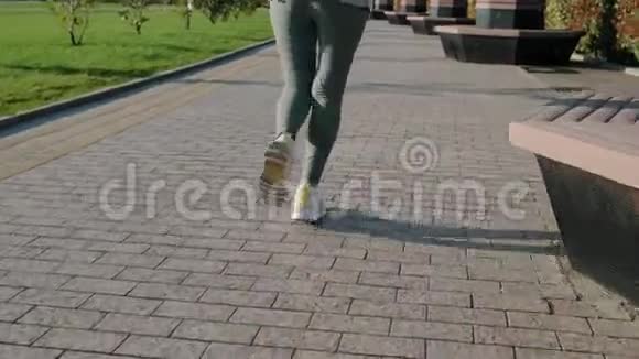 女跑步者在公园区慢跑后景腿部特写视频的预览图
