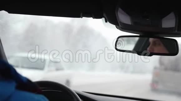 冬天下雪时开车的年轻人视频的预览图