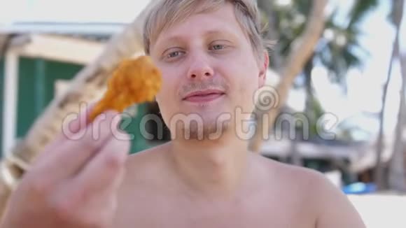 那个人在海滩上户外吃鸡翅快餐视频的预览图