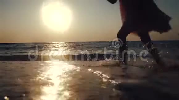 快乐的宝贝女孩在海水中奔跑美丽的日出在海滩上夏天的早晨视频的预览图