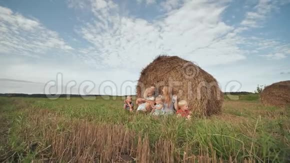 幸福的大家庭坐在田里一捆稻草附近视频的预览图