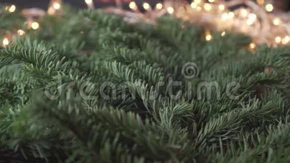 鲜艳的红色装饰丝带在圣诞树茂盛的树枝上以螺旋形的环状装饰得很漂亮视频的预览图