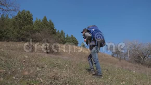 一个背着背包在森林里行走的人上升到一座小山旅游健康生活方式活跃视频的预览图