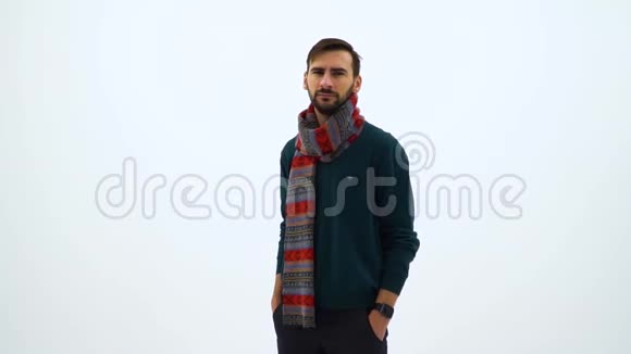 漂亮的慢镜头肖像帅哥穿绿色毛衣与新年围巾在镜头里看着一只的手臂视频的预览图