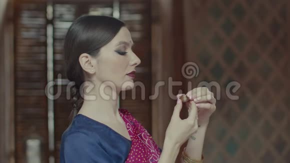 纱丽里的女人嗅着香囊的香味视频的预览图