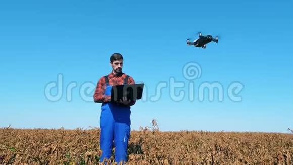 农学家站在农田里控制无人机视频的预览图