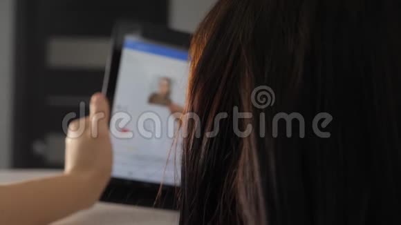 网上购物的概念年轻女孩坐在生活方式网上商店里看商品用数字购物视频的预览图