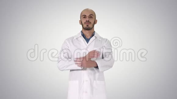 严肃的阿拉伯医生成熟男叉手臂在梯度背景视频的预览图
