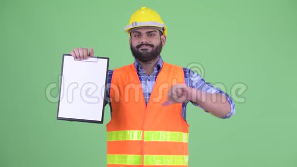 穿着超重胡须的印度建筑工人展示剪贴板并竖起大拇指视频的预览图