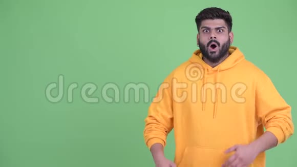 快乐的年轻体重超重留着胡子的印度男人露出了一些东西看上去很惊讶视频的预览图