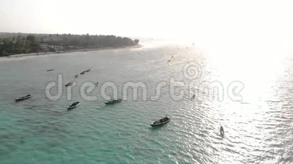 傍晚在桑给巴尔肯德瓦海滩上的传统的阿夫里海帆船有蓝色的印度洋鸟瞰图视频的预览图