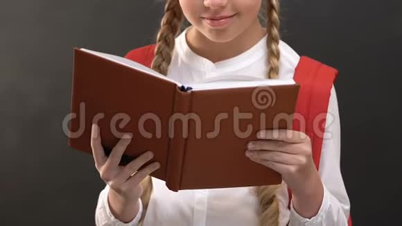 快乐的女学生看书对着黑板对着镜头微笑视频的预览图