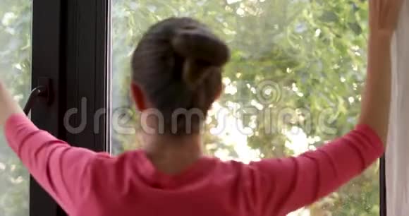 女人靠着窗户关上窗帘视频的预览图