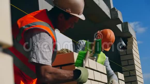 男工正在刷一堵新建的砖墙视频的预览图