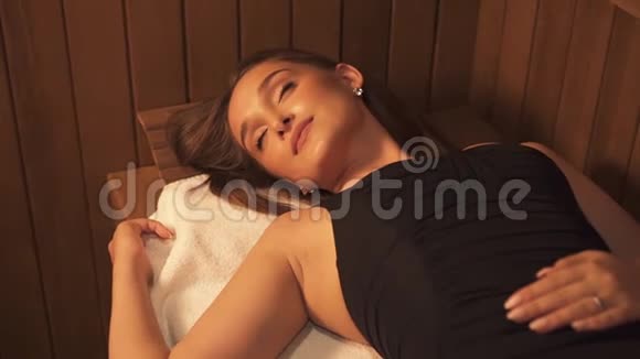美丽的孤立的热女人躺在蒸汽室的BNC上用白毛巾进行皮肤健康治疗视频的预览图