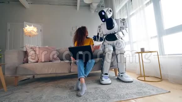 一个机器人和一个女人在笔记本电脑上说话智能家居概念视频的预览图