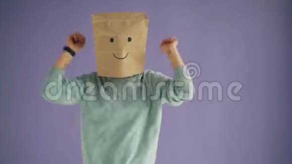 快乐女人的肖像头上有纸袋跳舞快乐放松视频的预览图