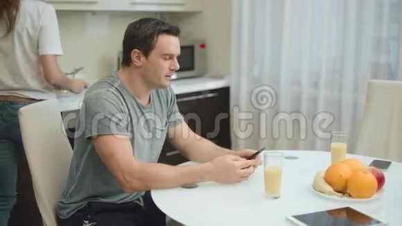 快乐夫妇在客厅健康早餐时喝橙汁视频的预览图