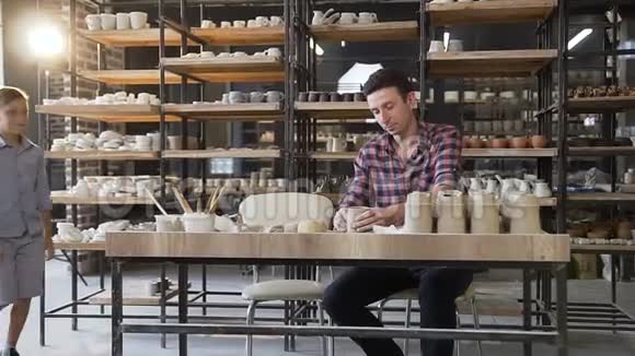 有魅力的白种人在他的儿子来陶器的时候制作陶罐视频的预览图