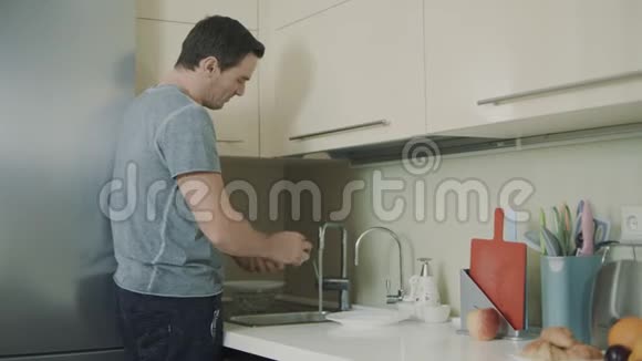 开朗的丈夫做家务微笑的人洗玻璃视频的预览图
