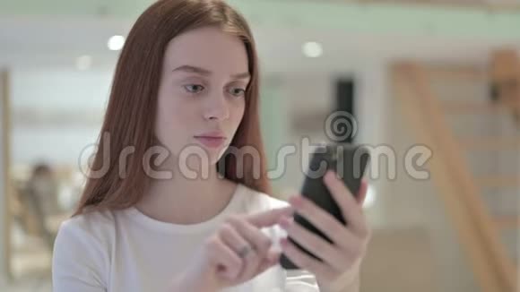 红头发年轻女性对智能手机丢失的反应视频的预览图