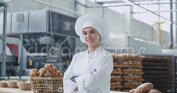 一个微笑的大美女面包师穿着时髦的制服直视着镜头的画像交叉了视频的预览图