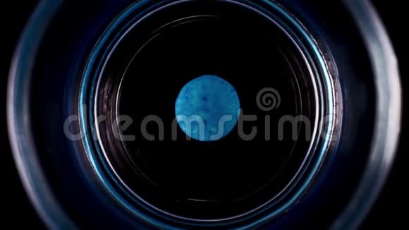 蓝色巧克力按钮溶解在水玻璃中的时间间隔视频的预览图
