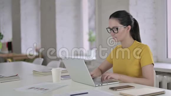 疲惫的年轻女设计师在现代办公室里的背痛视频的预览图