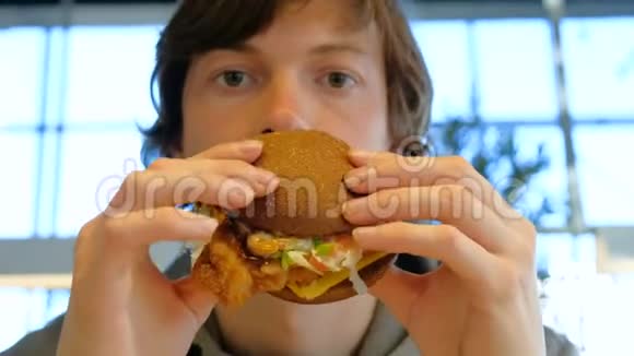 专心致志的家伙拿着汉堡包咀嚼特写镜头视频的预览图