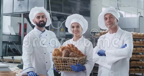 迷人的男人面包师和成熟的女人面包师带着一个带有机面包的老式篮子直视着相机和视频的预览图