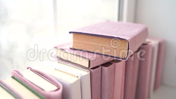 窗台上的一大堆书用彩色纸包裹的书躺在窗台上视频的预览图