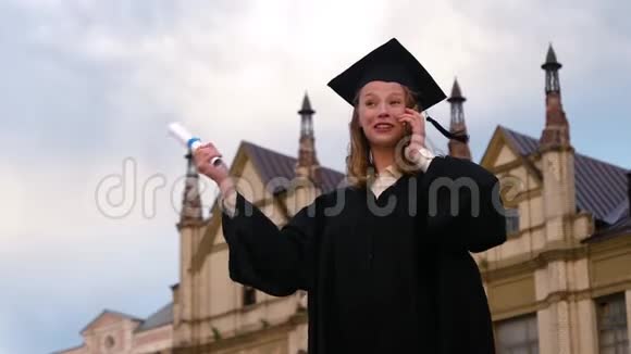 毕业典礼笑女在毕业时拨电话打电话视频的预览图
