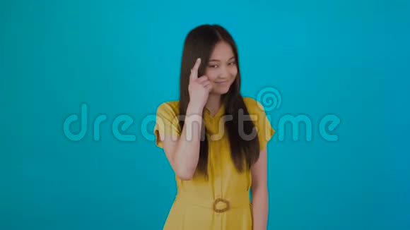 好的亚洲女孩表现出一种聪明的姿态网络梦一个笑话孤立于蓝色背景视频的预览图