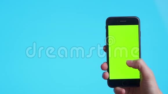女人手拿着绿色屏幕的黑色智能手机触摸或按下显示男人用手机带视频的预览图