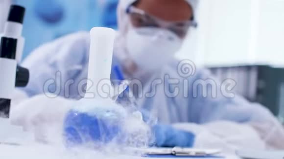在化学实验室里用试剂吸烟的蓝液鱿手持镜头视频的预览图