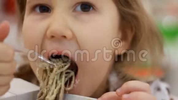 孩子吃有奶酪的意大利面肖像特写女孩在盒子里吃快餐面食视频的预览图