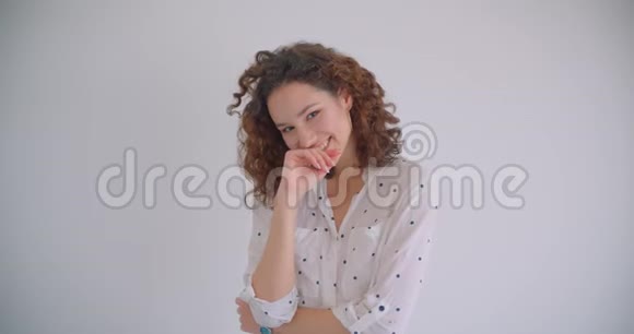 年轻漂亮卷曲的白种人女性笑着开心地看着有背景的镜头视频的预览图
