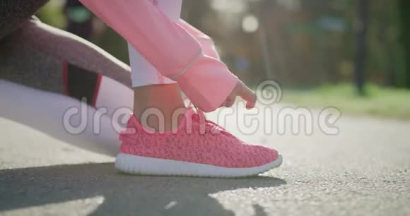女人双手系着她的运动鞋视频的预览图