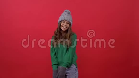 穿着绿色毛衣戴着红色背景帽子的女孩视频的预览图