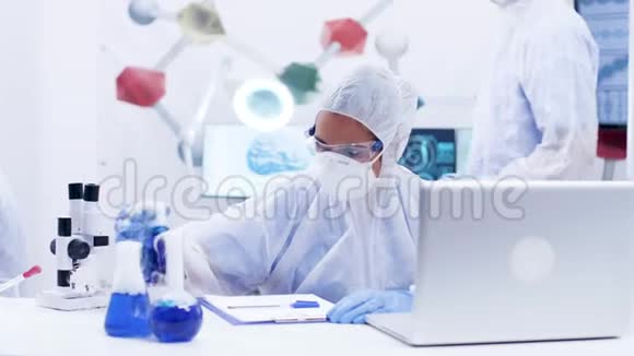 化学工业的一位科学家正在研究吸烟蓝液体穿戴罩设备视频的预览图