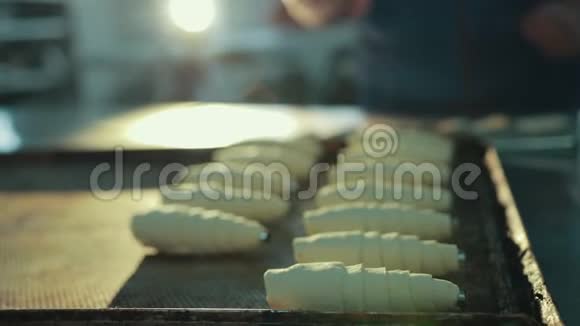 女性糖果师从烤箱里拿出一个未煮熟的牛角面包视频的预览图