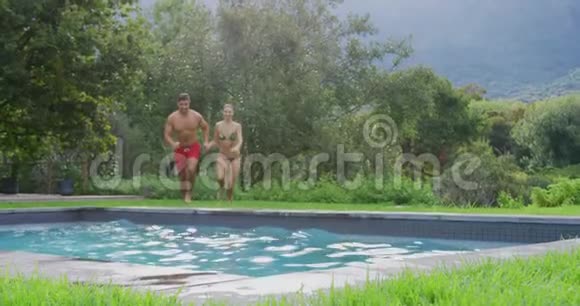 一对情侣在度假胜地4k的游泳池里跳在一起视频的预览图