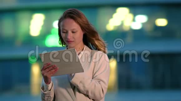女商人晚上在户外使用电子标签视频的预览图